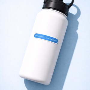 K&ouml;nnte beinhalten: Wei&szlig;e Wasserflasche mit schwarzem Deckel und Griff. Ein blauer Aufkleber auf der Flasche lautet: "Did I mention I ran a marathon?" Die Flasche befindet sich auf einem hellblauen Hintergrund.