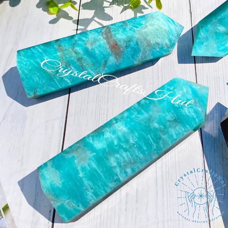 May include: Several rectangular Amazonite crystal obelisks with a polished finish. The crystals are a vibrant turquoise color with natural veining and markings. The image includes the text "Crystal Crafts Hub".