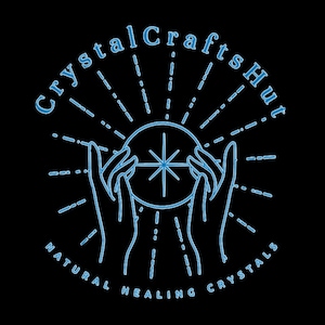 May include: A blue line drawing of two hands holding a crystal ball with a star inside. The text "Crystal Crafts Hut" is above the hands and "NATURAL HEALING CRYSTALS" is below the hands.