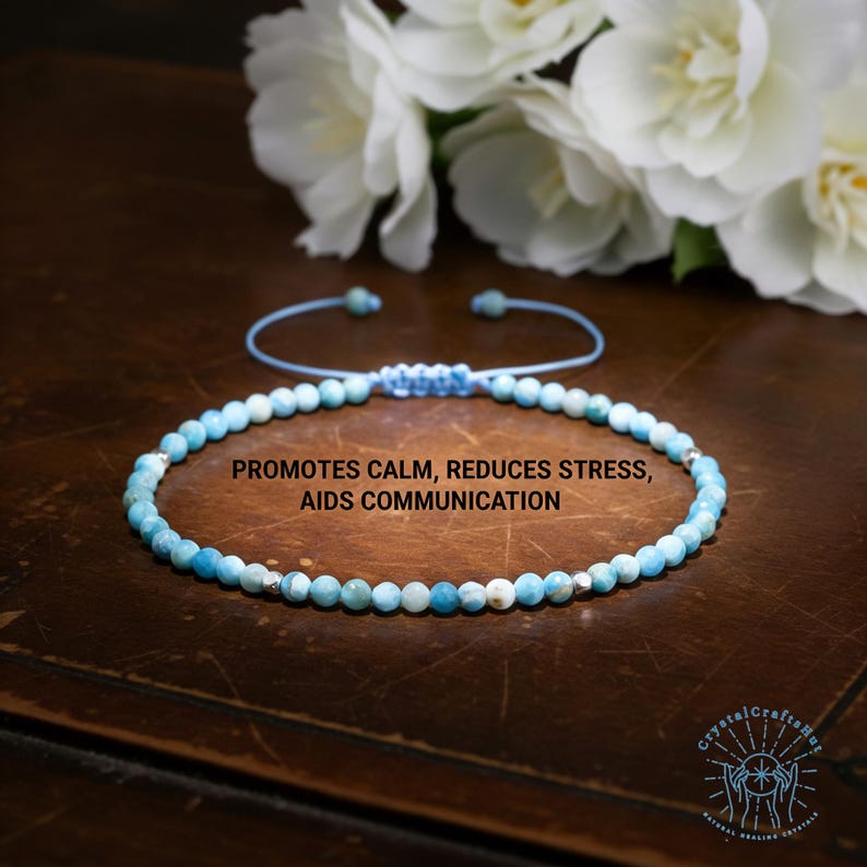 May include: A beaded bracelet with light blue and white beads. The bracelet is on a light blue cord with a sliding knot closure. Text on the image reads: PROMOTES CALM, REDUCES STRESS, AIDS COMMUNICATION.