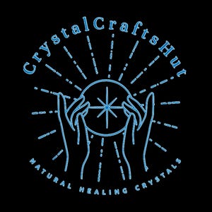 Pu&ograve; includere: Un disegno a linea blu di due mani che tengono una sfera di cristallo con una stella al suo interno. Il testo "Crystal Crafts Hut" &egrave; sopra le mani e "NATURAL HEALING CRYSTALS" &egrave; sotto le mani.
