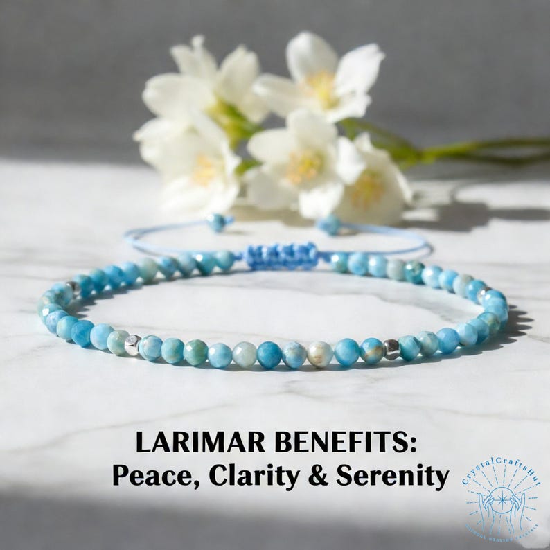 May include: A delicate blue Larimar beaded bracelet with a sliding knot closure. The bracelet is displayed with white flowers in the background. Text on the image reads "LARIMAR BENEFITS: Peace, Clarity & Serenity."