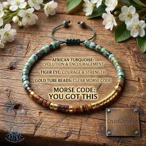 May include: A beaded bracelet with African turquoise, tiger eye, and gold tube beads. The bracelet features the Morse code message "YOU GOT THIS". The bracelet is displayed on a wooden surface with white flowers.