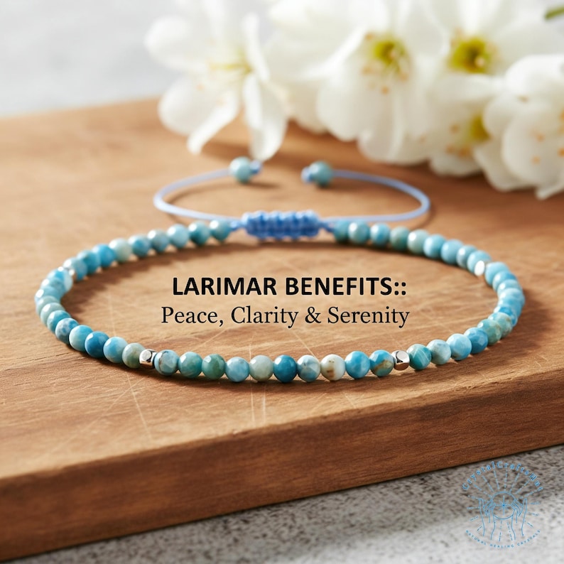 May include: A blue beaded bracelet with silver accents, displayed on a wooden surface. The bracelet is made of small, round, blue and white beads. Text on the image reads "LARIMAR BENEFITS:: Peace, Clarity & Serenity."