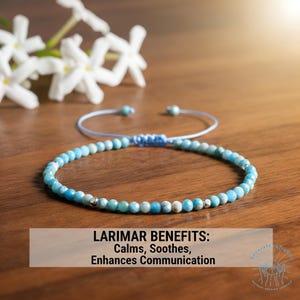 May include: A beaded bracelet with blue and white stones, set against a wooden surface. The bracelet is adjustable with a light blue cord. The text on the image reads: "LARIMAR BENEFITS: Calms, Soothes, Enhances Communication."
