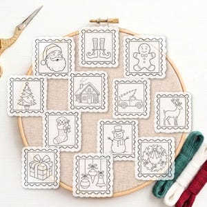 Può includere: Una collezione di dodici toppe quadrate in tessuto bianco con disegni a linee nere a tema natalizio, tra cui Babbo Natale, un omino di pan di zenzero, un pupazzo di neve, una renna, un albero, un regalo, una ghirlanda e decorazioni su un telaio.