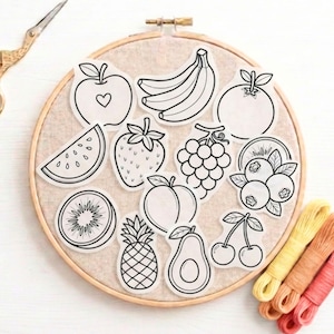 Può includere: Un telaio da ricamo contiene adesivi di frutta in bianco e nero, tra cui mela, banana, arancia, fetta di anguria, fragola, uva, kiwi, pesca, ananas, avocado, ciliegie e mirtilli. Forbici dorate e filo da ricamo colorato sono presenti.