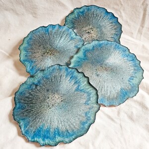 Labradoritinspirerade stora geodeunderlägg i epoxiharts, set om 4 med hållare. Handgjorda med grå, blå, gröna och glitterdetaljer.