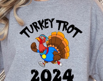 May include: Grey sweatshirt with a black graphic of a cartoon turkey running with the text "TURKEY TROT 2024"