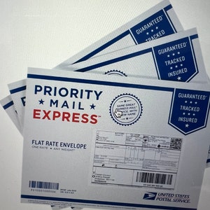 May include: A white Priority Mail Express flat rate envelope with a blue and red border. The envelope has a label with the text "Guaranteed, Tracked, Insured" and a barcode. The envelope is for shipping items within the United States.