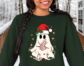May include: A dark green sweatshirt with a white ghost wearing a red Santa hat and holding a candy cane. The ghost is surrounded by colorful Christmas lights.
