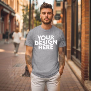 May include: A heather grey t-shirt with the text "YOUR DESIGN HERE" printed in white on the front.