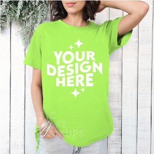 May include: A bright green t-shirt with a white design that says "YOUR DESIGN HERE" with small stars on either side of the text.