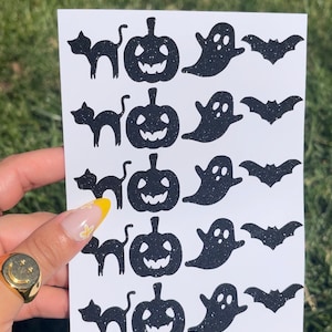 Könnte beinhalten: Eine Bogen mit schwarzen und weißen Halloween-Aufklebern mit fünf Reihen mit jeweils vier Aufklebern. Jede Reihe enthält eine schwarze Katze, einen schwarzen Kürbis, ein schwarzes Gespenst und eine schwarze Fledermaus.