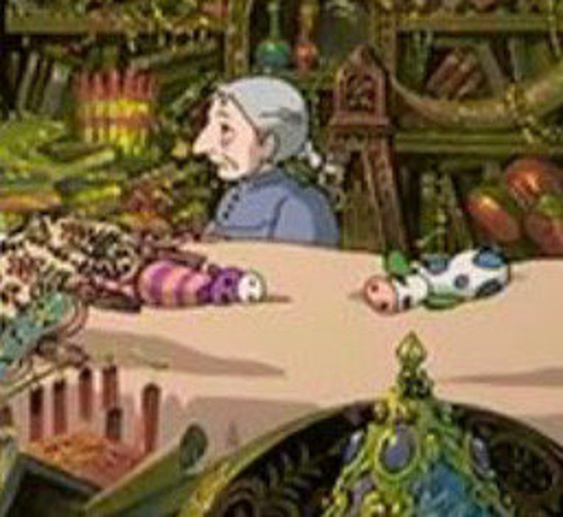 May include: A cluttered shop interior with a white table covered in a variety of colorful handmade toys. An older woman with gray hair sits at the table, looking to the left. The shop is filled with shelves of various items, including books, plants, and other crafts.