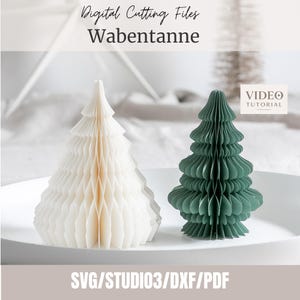 Puede incluir: Dos árboles de papel en forma de panal, uno blanco y otro verde oscuro, con el texto Digital Cutting Files Wabentanne y VIDEO TUTORIAL. El texto inferior enumera los formatos de archivo SVG, STUDIO3, DXF y PDF para estas decoraciones.