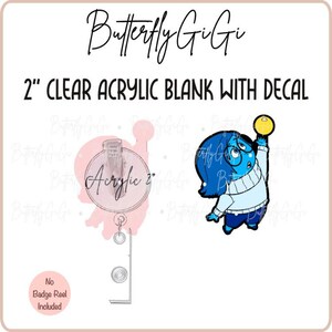 May include: A 2 inch clear acrylic blank with a decal of a blue character with glasses holding a yellow ball. The character is from the movie Inside Out. The text "Butterfly Gigi" is at the top of the image. The text "2" CLEAR ACRYLIC BLANK WITH DECAL" is below the Butterfly Gigi text. The text "No Badge Reel Included" is at the bottom of the image.