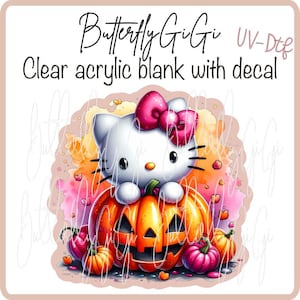 May include: A clear acrylic blank with a decal featuring a white cartoon cat with a pink bow, sitting on a carved orange pumpkin. The image includes smaller pumpkins and hearts, with the text "Butterfly GiGi" and "Clear acrylic blank with decal".