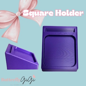 May include: Two purple square holders are displayed against a light blue background. One holder is upright, and the other is angled. The text "Square Holder" is in pink above the upright holder. A pink bow is in the upper left corner. The text "Butterfly Gigi" is in the lower left corner.
