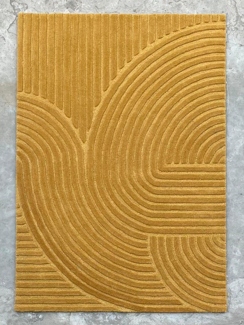 May include: A mustard yellow rug with a geometric pattern of curved lines.