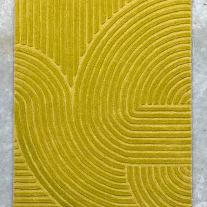 May include: A yellow rug with a geometric pattern of curved lines. The rug has a textured surface and a modern design.