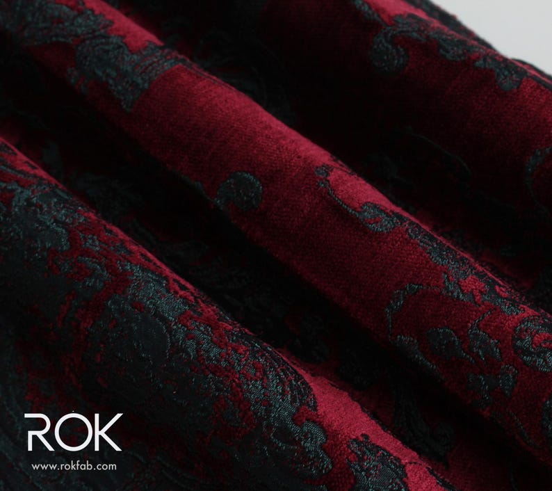 May include: Close-up of a burgundy fabric with a black floral pattern. The fabric is folded, showing the texture and design. The text "ROK" and website address are visible in the lower left corner.