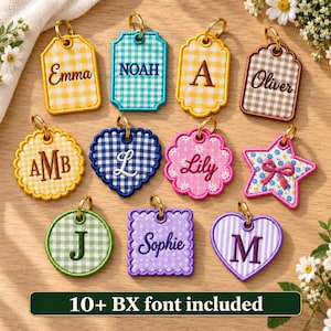 May include: A collection of eleven fabric tags in various shapes including rectangles, circles, hearts, and a star, featuring gingham, floral, and striped patterns. Each tag displays embroidered names or initials like Emma, Noah, A, Oliver, AMB, L, Lily, J, Sophie, and M, with gold-tone metal rings attached.