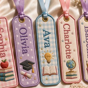 May include: Five rectangular fabric bookmarks with embroidered names and motifs. From left to right: Sophia with books and apple, Olivia with graduation cap and scroll, Ava with lightbulb and book, Charlotte with globe and books, and Isabella with pencils.