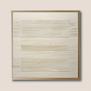 Pode incluir: Arte de parede abstrata emoldurada em madeira. A obra apresenta uma superfície texturizada esbranquiçada com três áreas retangulares de linhas horizontais. A moldura é de cor castanho claro, e a estética geral é minimalista e moderna.