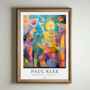 May include: A framed art print of a colourful abstract floral design by Paul Klee. The artwork displays a vibrant mix of blues, yellows, oranges, and purples, with geometric shapes and botanical elements. The print includes the artist's name, location, and year.
