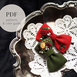 以下が含まれることがあります： 手作りの布製蝶ネクタイ2つ。赤と緑で、刺繍された花の模様があります。赤い蝶ネクタイにはバラ、緑には柑橘類とベリーのモチーフがあります。テキスト：PDFパターンとカラーガイド。