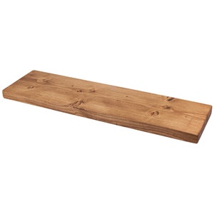 Handcrafted rustic floating shelf made of reclaimed wood. Features a natural finish, highlighting wood grain & knots. Perfect for farmhouse or vintage decor. Ideal for displaying books, plants & decor items. Eco-friendly & sustainable choice for home