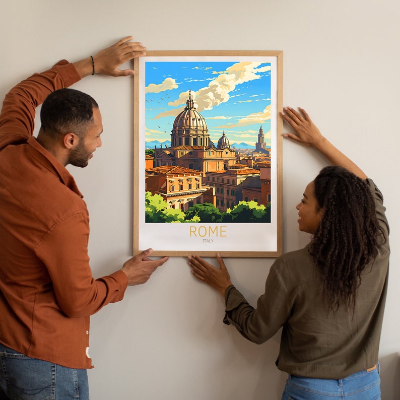 May include: A couple are hanging a framed print of a colourful illustration of the skyline of Rome, Italy. The print features a large domed building and other buildings in the background. The text "ROME" and "ITALY" is printed in gold at the bottom of the print.