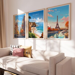 Puede incluir: Tres carteles de viaje enmarcados con paisajes urbanos. El cartel de la izquierda presenta un paisaje urbano de Nueva York con el texto "NEW YORK" en la parte superior. El cartel del medio presenta una escena de playa con el texto "ALGARVE" en la parte superior. El cartel de la derecha presenta la Torre Eiffel en Par&iacute;s con el texto "PARIS" en la parte superior.
