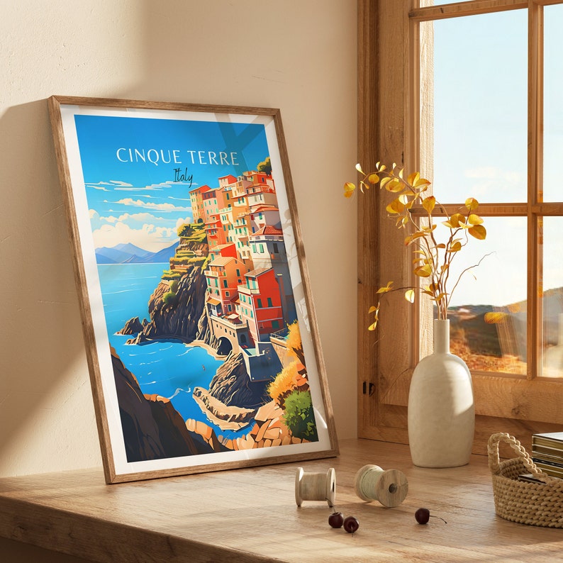 May include: A framed print of a colorful illustration of the Italian village of Cinque Terre, with the text "Cinque Terre Italy" at the top.