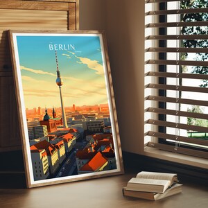 May include: A framed print of a cityscape with the Berlin Television Tower in the center. The print has a vintage travel poster aesthetic with the word "BERLIN" in a bold font at the top.