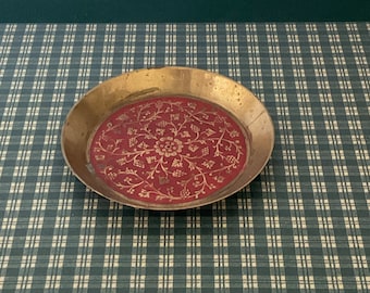May include: A small, round brass tray with a red centre and gold floral design.