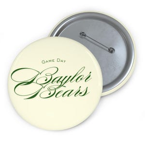 May include: Two round cream-colored buttons with a pin back. One button is in front of the other. The front button has the words "Game Day" above the words "Baylor Bears" in green script.