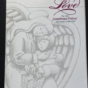 Puede incluir: Una caja rectangular blanca con un boceto a lápiz gris de un ángel sosteniendo a un niño con una cesta. El texto dice Love, The 1995 Longaberger Pottery Angel Series Cookie Mold. La caja tiene un fondo blanco y texto oscuro.