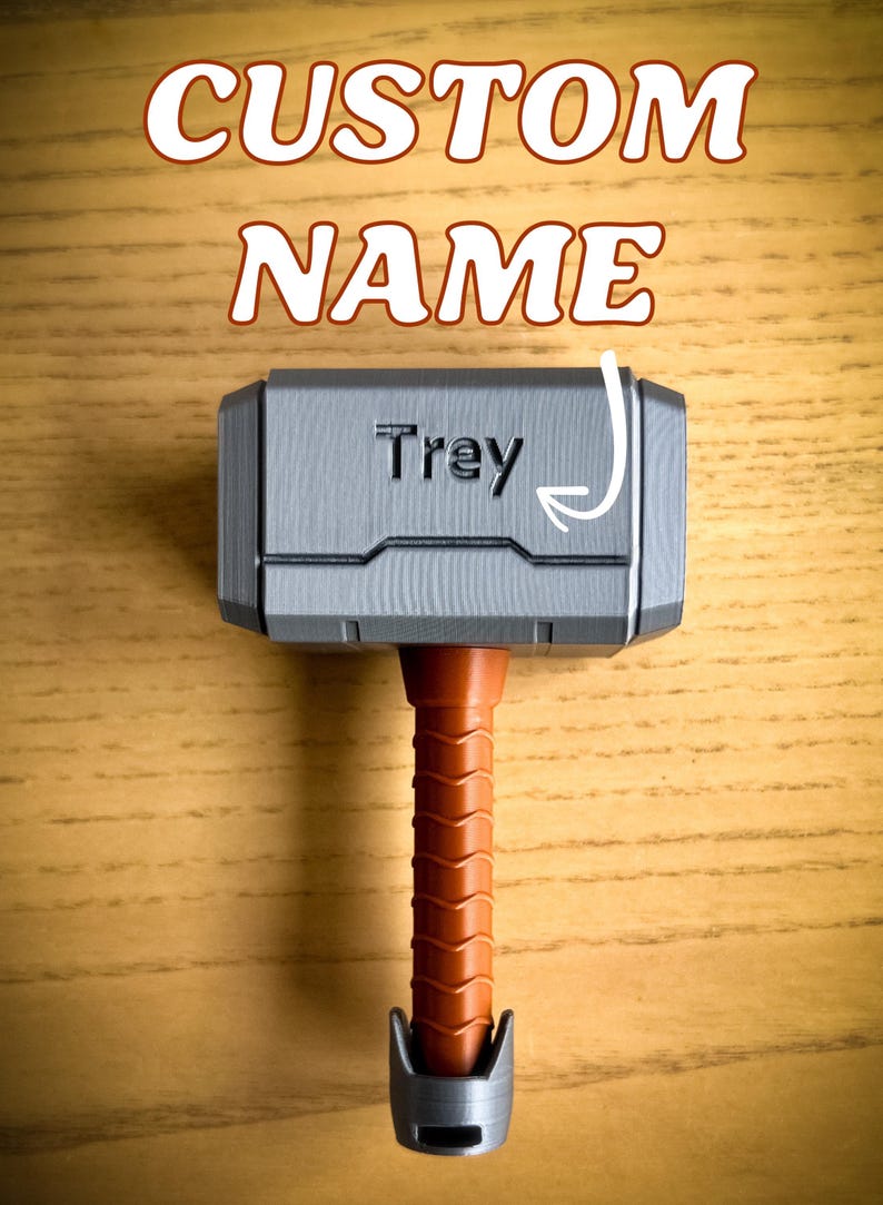 Custom engraved Thor hammer baby rattle with vibrant handle colors including pink, yellow, black, brown, and light blue. A personalized baby rattle and creative custom baby gift that’s also a fun 3D printed toy.