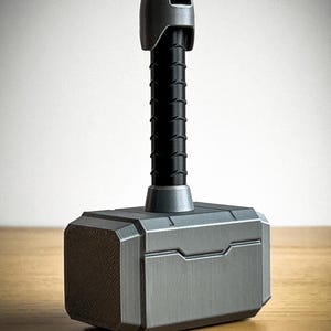 May include: A silver-colored, 3D printed replica of Thor's hammer, Mjolnir. The hammer has a black handle with a textured surface and a silver-colored head with a raised design.