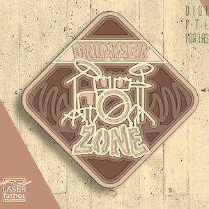 Könnte beinhalten: Ein braunes und beiges schildförmiges Schild mit den Worten "Drummer Zone" und einer Schwarzweißillustration eines Schlagzeugs im Inneren. Das Schild ist für den Laserschnitt konzipiert.