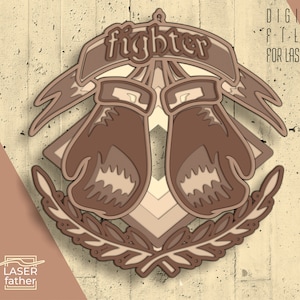 Puede incluir: Un diseño en capas para corte por láser que presenta dos guantes de boxeo con la palabra "fighter" encima. Los guantes son marrones y beige y están rodeados por una corona de hojas.