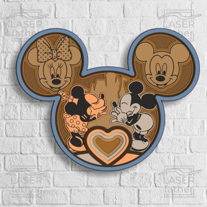 Puede incluir: Una silueta azul de la cabeza de Mickey Mouse con un diseño en capas marrón y beige. Dentro de la silueta hay imágenes de Mickey y Minnie Mouse besándose, con un diseño de corazón en capas en el centro.