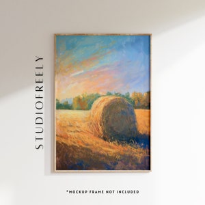 May include: Framed landscape painting featuring a large hay bale in a field under a colorful sky. The artwork has a warm color palette with shades of yellow, orange, and blue. The text "STUDIOFREELY" is printed vertically on the left side of the frame. The text "*MOCKUP FRAME NOT INCLUDED" is printed at the bottom.