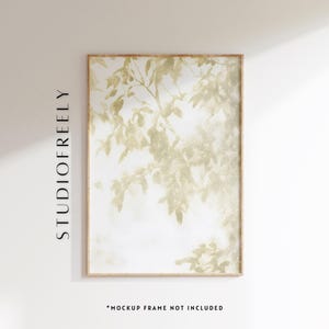 May include: A framed art print featuring a botanical design. The artwork showcases a light beige foliage pattern against a white background. The frame is a light brown color. The text "STUDIOFREELY" is printed vertically on the left side of the frame. The text "*MOCKUP FRAME NOT INCLUDED" is printed at the bottom.