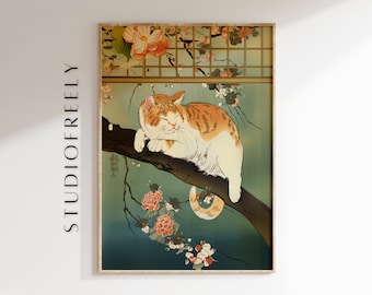 Op de afbeelding: Een ingelijste prent met een kat die op een tak rust, in de stijl van een Japanse houtsnede. De kat is oranje en wit, met gesloten ogen. De achtergrond is blauwgroen en toont bloemen en een raam.