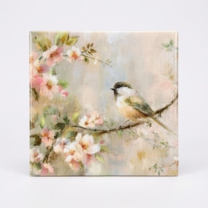 Puede incluir: Arte en lienzo cuadrado que representa un pájaro en una rama con delicadas flores rosas. La obra de arte tiene un estilo suave y pictórico con un fondo neutro, creando una escena serena y natural. El pájaro tiene plumas marrones, blancas y verdes.