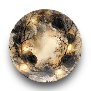 May include: Round decorative plate with a watercolor design. The plate features a central light-colored area surrounded by dark branches, black fan-shaped elements, and glowing orbs. The color palette includes shades of brown, black, and gold.