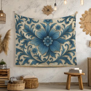 以下が含まれることがあります： 中央に青い花の模様と渦巻く葉の模様が施された、大きな長方形のタペストリー。タペストリーは壁に掛けられており、青とクリームの色合いが含まれています。全体的なスタイルは装飾的で華やかです。